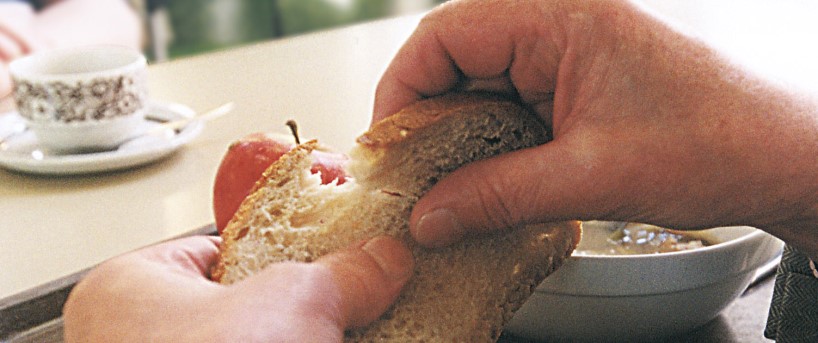 Hände brechen ein Brot bei eva's Tisch